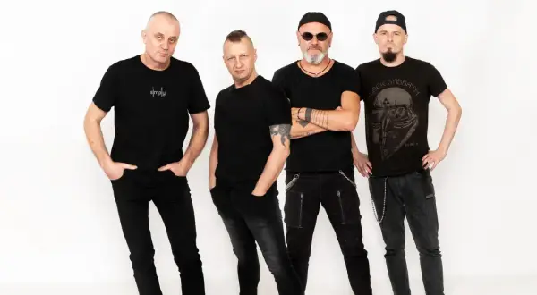 Czterech mężczyzn w czarnych ubraniach, tworzących zespół. Jeden z nich ma na koszulce napis "simply", inny koszulkę z logo Black Sabbath.