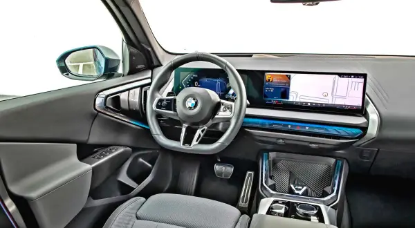 Wnętrze nowoczesnego x3 bmw z dużym ekranem nawigacji i cyfrowymi zegarami.