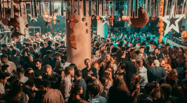 Folla giovane in una discoteca di Barcellona, forse per festeggiare i 17 anni. Luci soffuse e musica alta creano l'atmosfera perfetta per ballare tutta la notte.