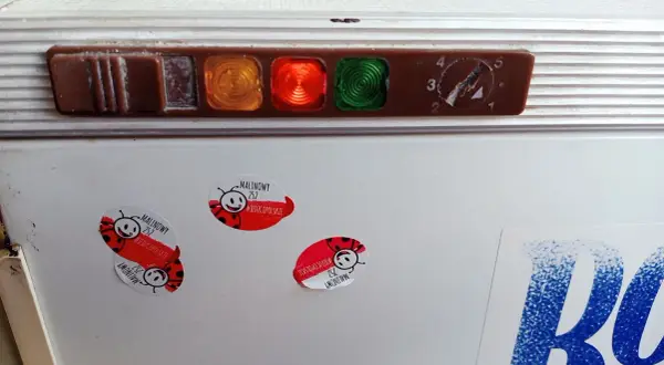 Stara lodówka Polar z kontrolkami i pokrętłem termostatu. Na drzwiach naklejki z biedronkami i napisem "Malinowy".