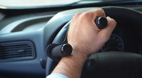 Mano con ausilio per sterzare, facilitando i comandi auto per chi ha difficoltà di presa.
