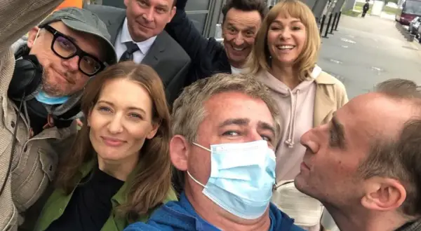 Uśmiechnięta usta usta obsada na planie zdjęciowym. Wszyscy w dobrych humorach, gotowi do pracy.