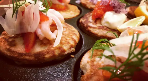 Små, gyllene blinier med räkor, dill och rödlök. Ett perfekt blinier recept för en festlig förrätt.