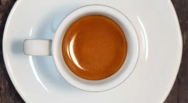 Tazzina di caffè espresso con crema dorata, risultato di un'accurata lavorazione del caffè.