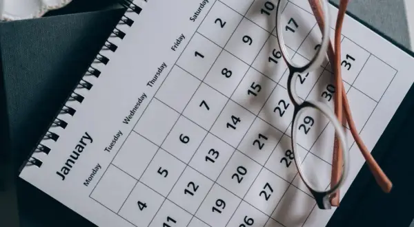 Okulary na kalendarzu z napisem "January". Planowanie ważnych terminów, np. Kindergeld termine, wymaga organizacji.