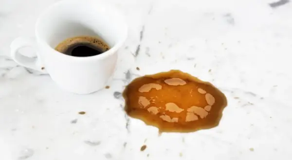 Tazza di caffè rovesciata su marmo bianco. Scopri come pulire il marmo macchiato dal caffè.