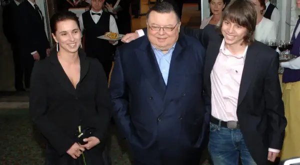 Wojciech Mann z córką i synem. Uśmiechnięci pozują do zdjęcia w eleganckich strojach.