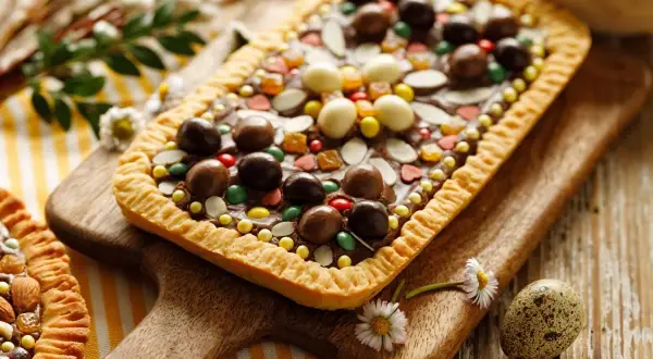 Pyszny mazurek fit z czekoladą i bakaliami, ozdobiony kolorowymi drażetkami i migdałami. Idealny na Wielkanoc.