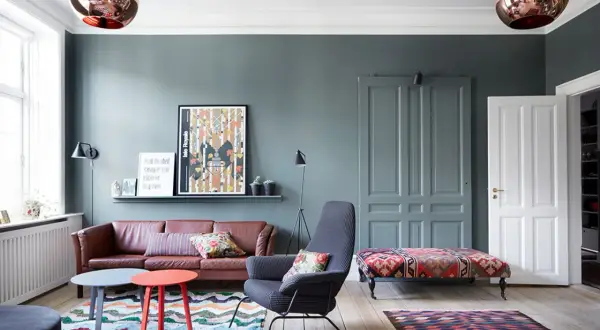 Gemütliche, bunte Wohnung mit Ledersofa, gemusterten Teppichen und auffälligen Lampen.
