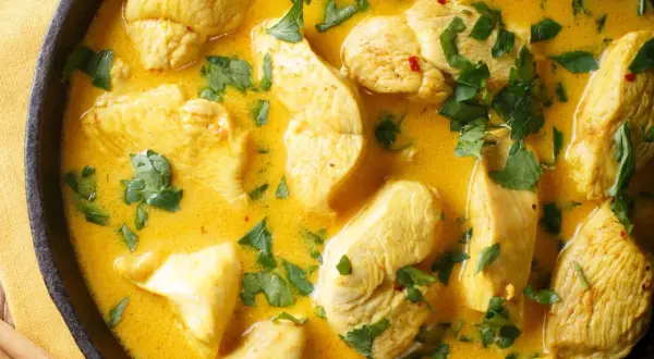 Ein klassisches Curry-Hähnchen-Rezept in cremiger Sauce, garniert mit frischer Petersilie.