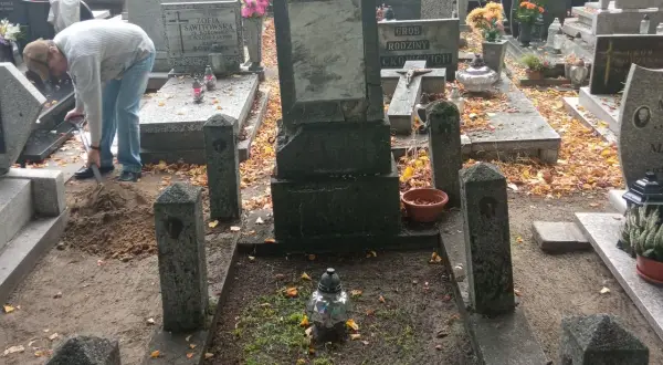 Na cmentarzu, wśród jesiennych liści, osoba kopie ziemię przy grobie. Czy dusze nas słyszą?
