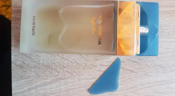 Perfumy Dolce & Gabbana Light Blue, w odcieniu niebieskim, na drewnianym tle.