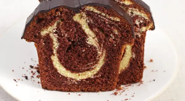 Zwei saftige Scheiben Marmorkuchen mit Schokoladenglasur, perfekt für ein schnelles Marmorkuchen Rezept.