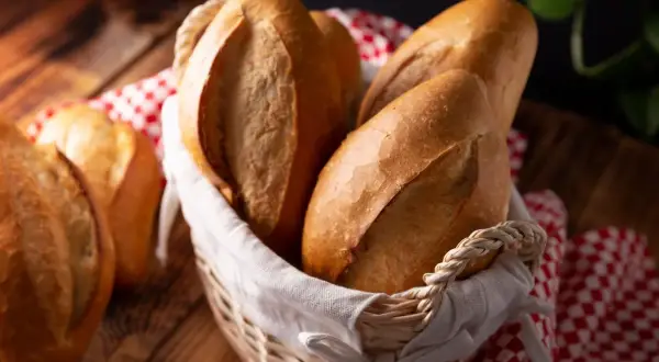 Koszyk pełen świeżego, pachnącego chleba z piekarnika, z chrupiącą skórką i miękkim wnętrzem. Idealny na śniadanie.