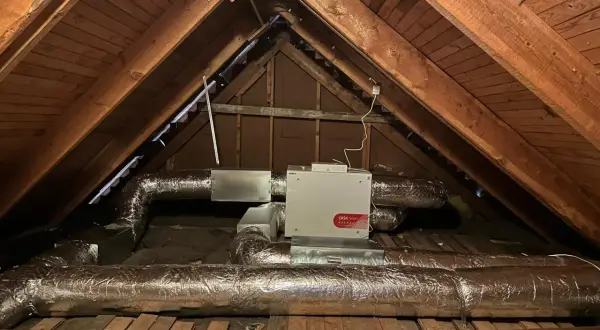 FTX-installation i en vind med isolerade ventilationsrör och en vit enhet märkt "CASA Smart".