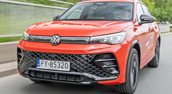 Nowy Tiguan w jaskrawym kolorze jedzie po drodze.