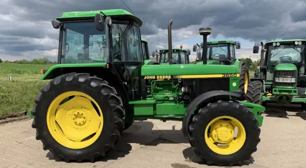 Zielony traktor John Deere 3650 z żółtymi felgami, gotowy do pracy na polu.