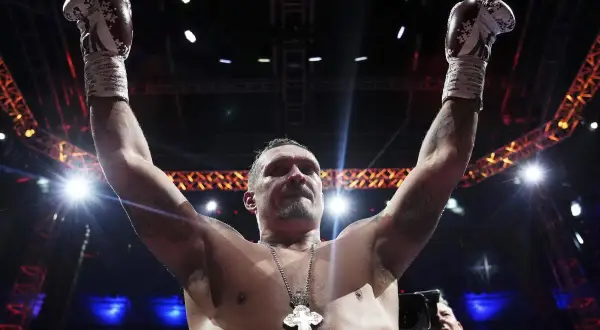 Boxer Oleksandr Usyk raises his arms in victory, his gloves high. He's a seasoned pro, not one of those top heavy amateurs.