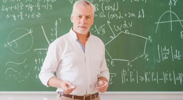 Nauczyciel z tablicą pełną wzorów matematycznych, jakby potrzebował urlop dla poratowania zdrowia po długim semestrze.