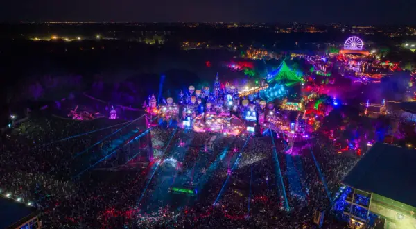 Nocny festiwal Tomorrowland 2026 w pełni. Tłumy ludzi, kolorowe światła, sceny w kształcie zamków i latające balony tworzą magiczną atmosferę.