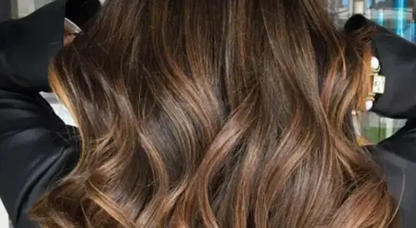 Glänzendes, glattes Haar mit Balayage in Braun-Caramel-Tönen, das wie flüssiges Gold fällt.