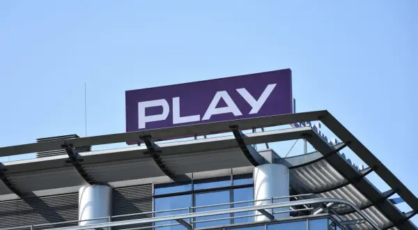 Logo PLAY na dachu budynku. Zastanawiasz się, co to roaming krajowy? To usługa, która pozwala korzystać z sieci innego operatora w Polsce.
