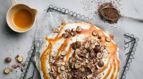 Ein köstlicher Banoffee-Kuchen, dekoriert mit Karamell, Schokostückchen und ganzen Schokokugeln. Perfekt für dein nächstes Banoffee Rezept!