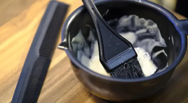 Mieszanka do farbowania włosów, jak do Casting Creme Gloss, gotowa do nałożenia na suche lub mokre włosy. Obok grzebień.