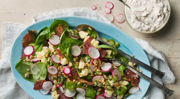 En härlig italiensk sallad med sparris, rädisor, salami och pinjenötter, serverad med en krämig dressing.
