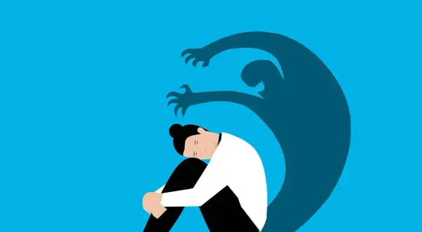 Una persona rannicchiata, oppressa da un'ombra minacciosa. Rappresentazione visiva dell'angoscia, il suo significato psicologico.