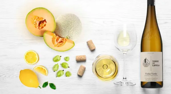 Letnia kompozycja z melonem, cytryną, agrestem i kieliszkiem orzeźwiającego **vinho verde**.