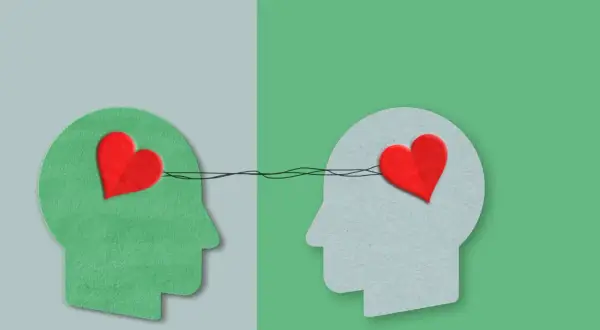 Twee profielen met harten verbonden door lijnen, symboliseren autisme en empathie.