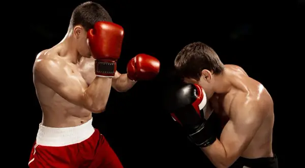 Two boxers spar intensely. The dedication shown hints at how many hours boxers train a day to reach this level of skill and conditioning.