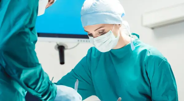 Chirurg wykonuje zabiegi dermatologiczne, skupiony na pracy.