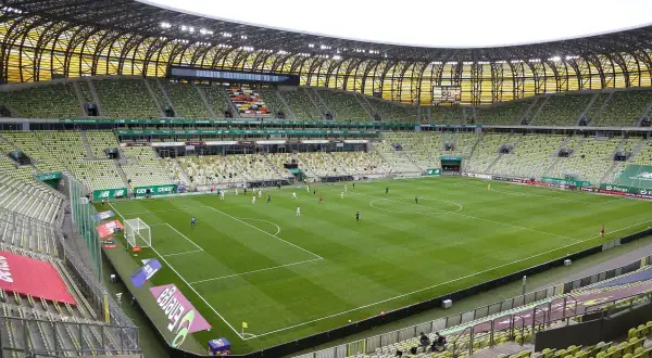 Polsat Plus Arena Gdańsk, z zielonymi trybunami, gotowa na mecz. Jej pojemność pozwala na przyjęcie tysięcy kibiców.