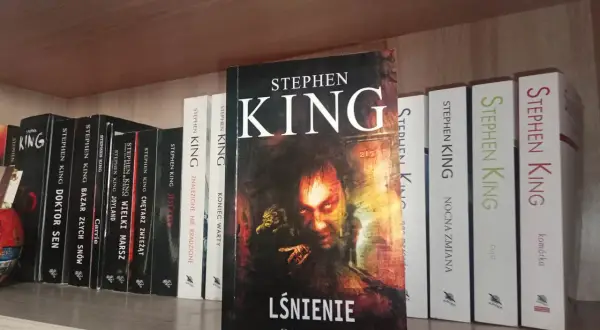 Półka z książkami Stephena Kinga, w tym "Lśnienie", "Cmętarz zwierząt" i "Nocna zmiana".