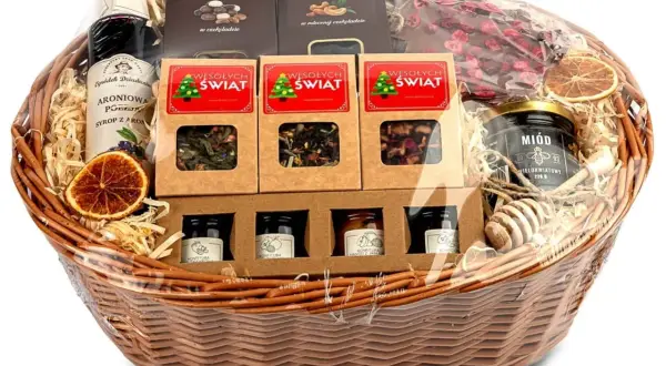 Wesołych Świąt! Kosz prezentowy świąteczny pełen słodkości: syrop aroniowy, miód, konfitury, herbaty i czekoladki.
