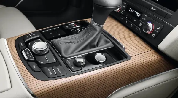 Eleganckie drewniane wykończenie konsoli środkowej Audi z dźwignią skrzyni biegów multitronic i przyciskiem Start/Stop.