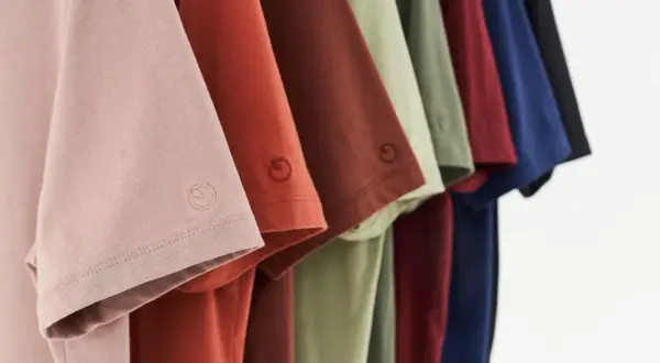 Reihe von T-Shirts in verschiedenen Farben. Lyocell Stoff Nachteile sind hier nicht sichtbar, aber die Qualität ist erkennbar.