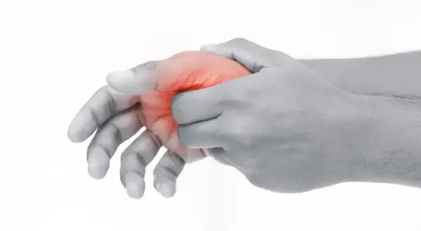 Schmerzende Hand, die den Daumen mit roter Markierung hält, was auf Schmerzen im Daumengelenk hinweist.