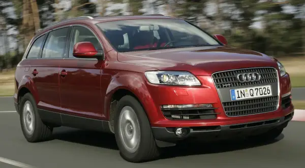 Czerwony Audi Q7 w ruchu. Sprawdź aktualną audi q7 cena i możliwości tego luksusowego SUV-a.