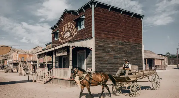 Un vaquero conduce un carro tirado por caballos por un pueblo del Salvaje Oeste en el desierto de Tabernas y Oasys Minihollywood.