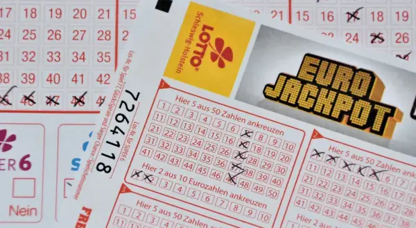 Kupony lotto z zaznaczonymi liczbami i logo Eurojackpot. Zastanawiasz się, ile podatku od wygranej zapłacisz?