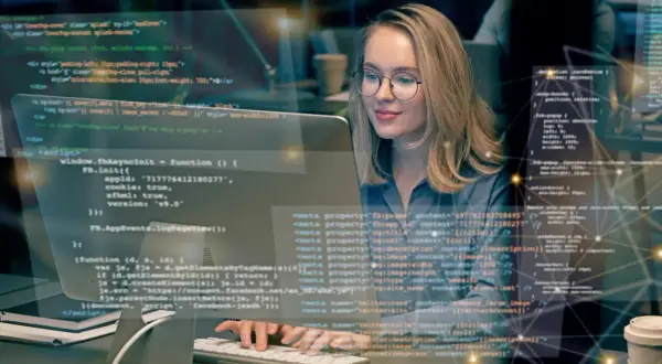 Frau lernt Programmieren im Fernstudium. Sie arbeitet konzentriert an ihrem Computer, um Fachinformatiker zu werden.