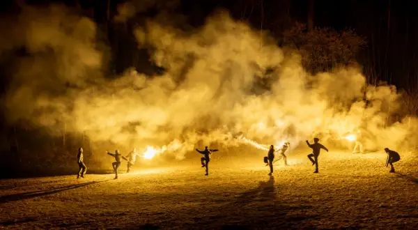 Silvia Gallerano e un gruppo di persone danzano tra fumo e bengala, creando un'atmosfera magica e un po' caotica, quasi come se stessero scacciando "la merda" della vita.