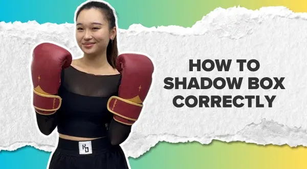 A young woman in boxing gloves smiles, ready to teach you how to shadow box correctly.