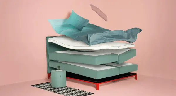 Schichtweise aufgebautes Bett mit Matratzen, Kissen und Bettwäsche. Hilft bei der Entscheidung, welches Bett passt zu mir.