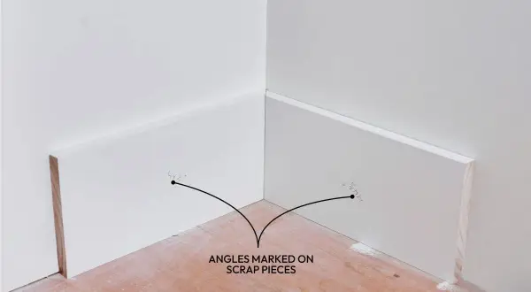 Angoli segnati su pezzi di scarto per mostrare come tagliare i battiscopa in ceramica a 45 gradi.