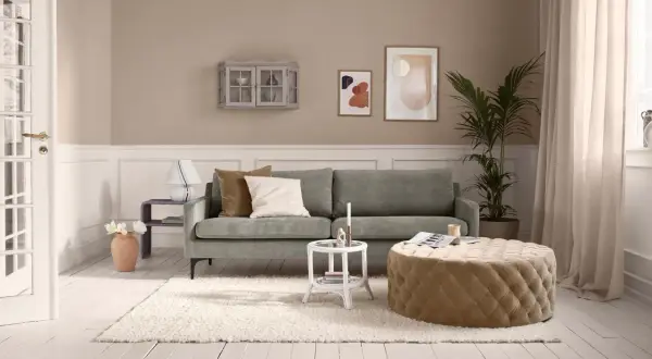 Gemütliches Wohnzimmer: Ein grünes Sofa, ein beiger Hocker und ein flauschiger Teppich verwandeln jeden kleinen Raum einrichten.