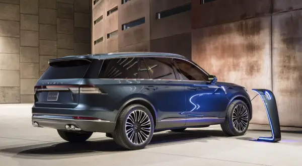 Elegancki, niebieski Lincoln Aviator ładowany przy futurystycznej stacji. Nowoczesność i moc w jednym.
